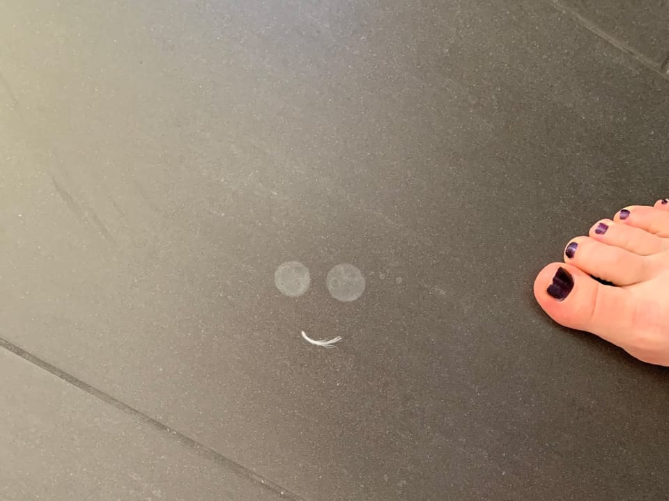 Füsse und Flecken in Form eines Smileys auf Boden