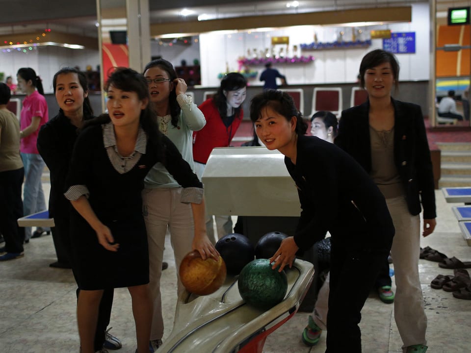 Frauen spielen auf einer Bowlingbahn.
