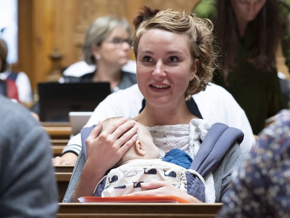 Irene Kälin sitzt im Nationalrat mit ihrem Baby auf dem Schoss. 
