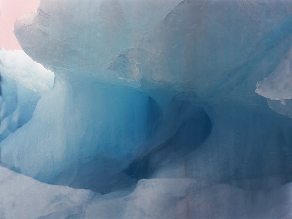 Hellblaues Eisgebilde, das wie Meereswellen aussieht. 