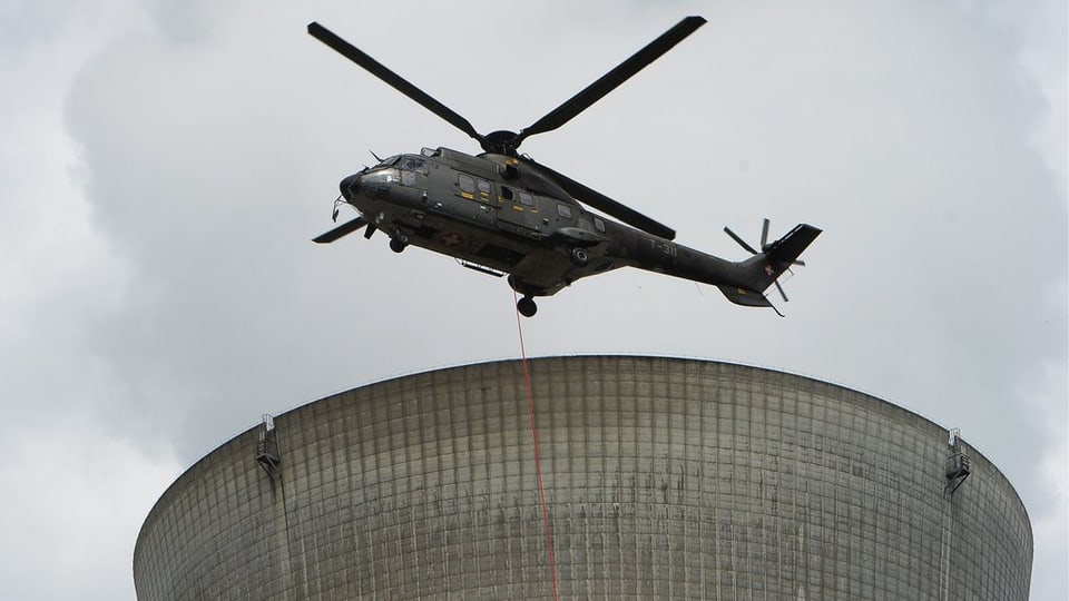 Hubschrauber über Kühlturm von AKW.