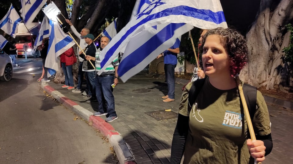 Amit Nachmany mit israelischer Flagge an einer Demonstration