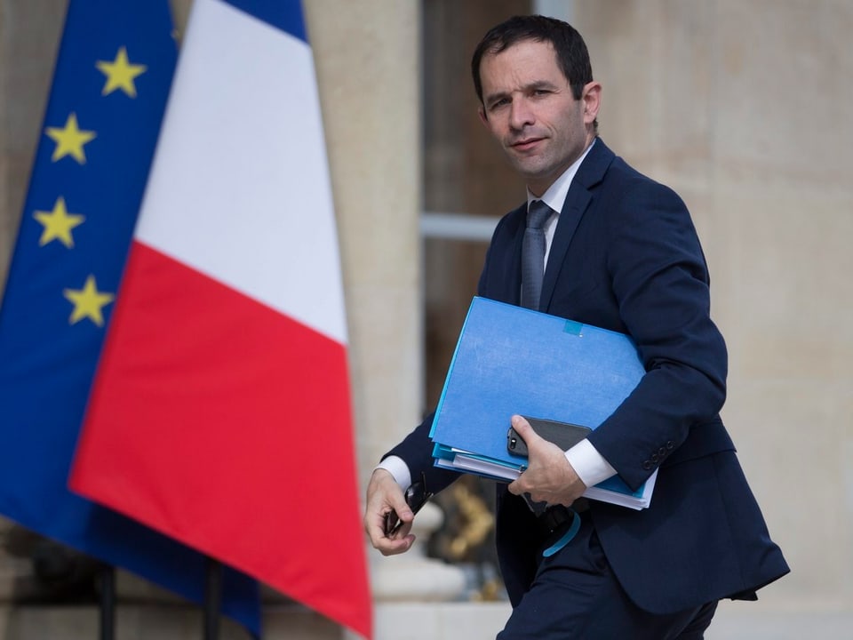 Benoît Hamon vor der Frankreich- und EU-Flagge.