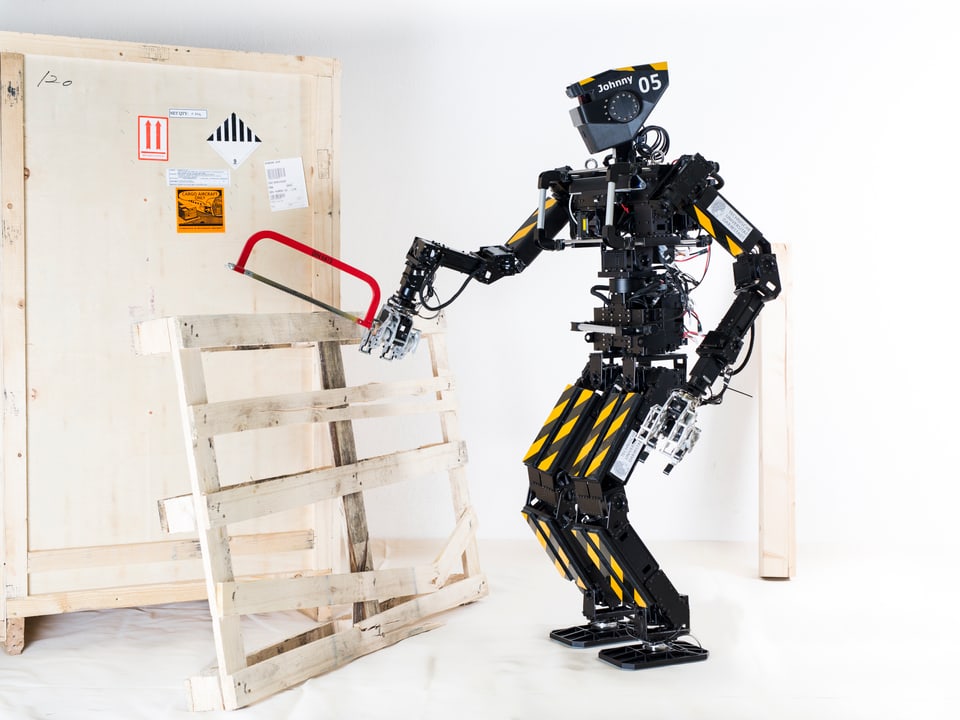 Ein Roboter hält eine Säge an ein Holzbrett.
