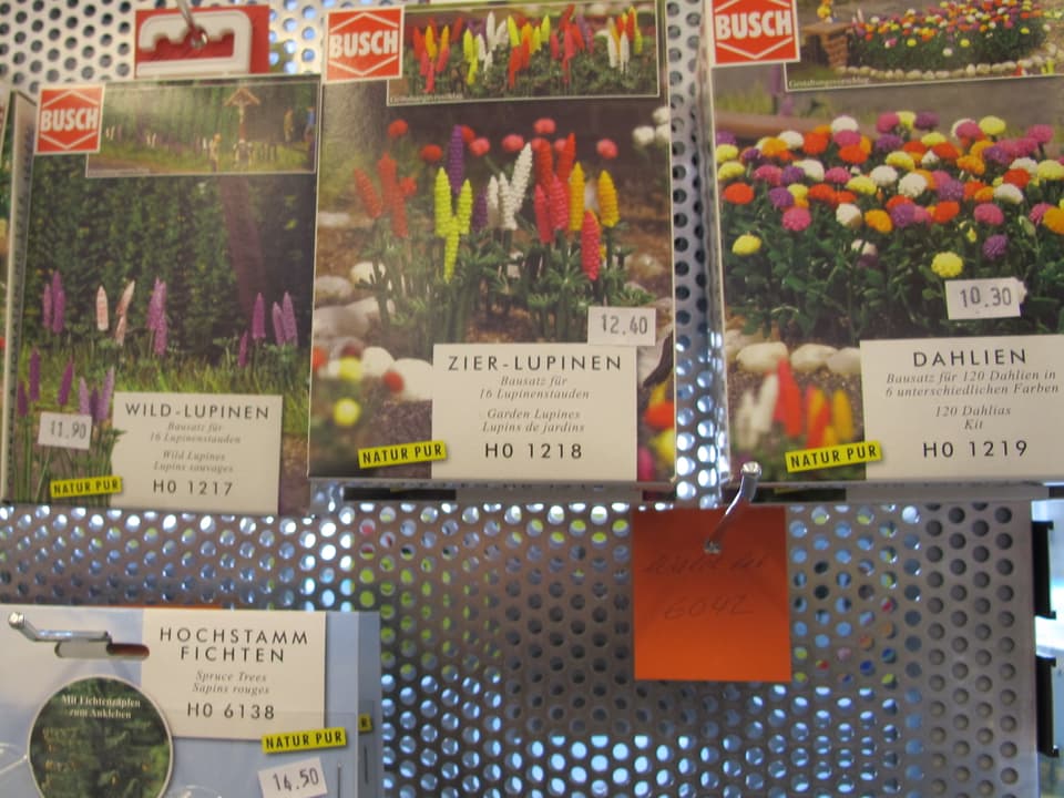 Auslage von verschiedenen Modellbau-Blumen, Kartons sind angeschrieben mit "Wild-Lupinen", Dahlien etc.
