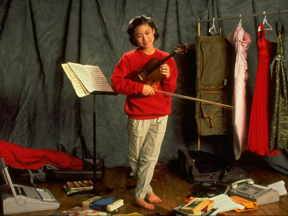 Midori posiert mit Geige als Kind.