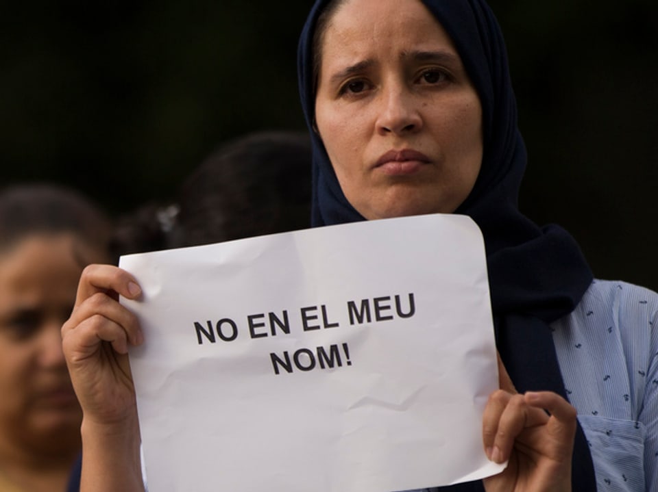 Frau mit Plakat mit der Aufschrift «Nicht in unserem Namen».