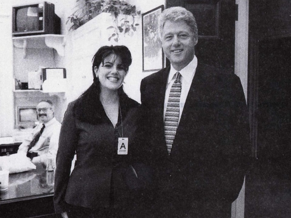 Lewinsky und Clinton posieren in einem Büro.
