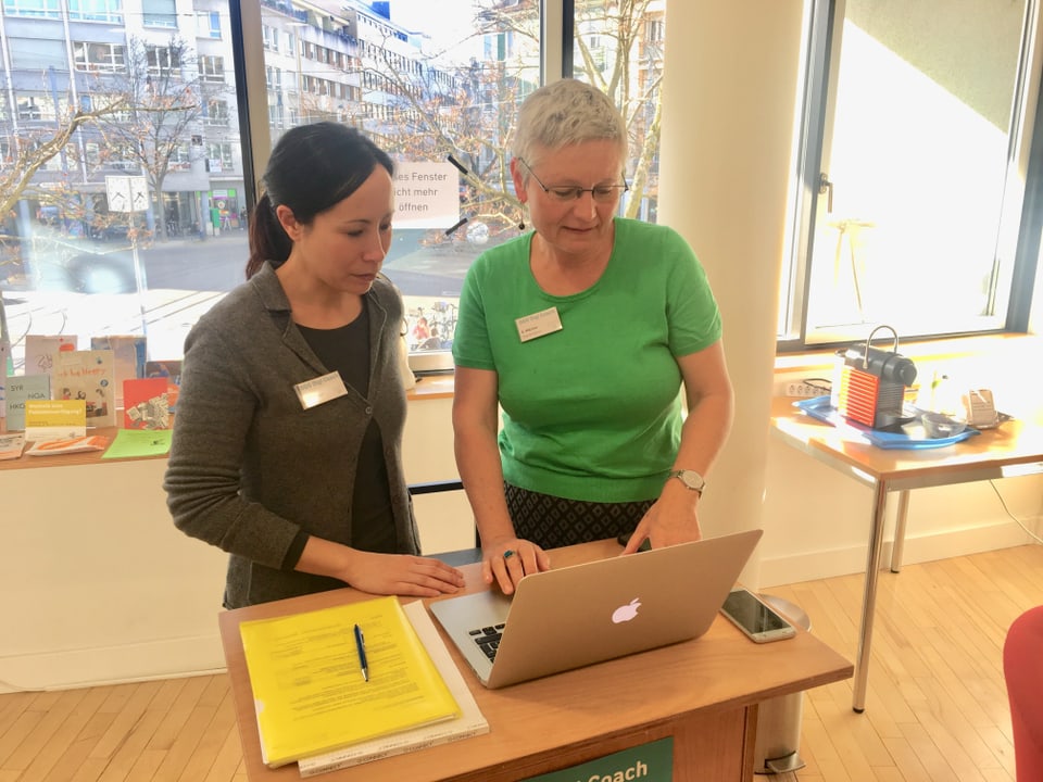 Digitalcoaches Manon Wacker (links) und Gabi Mächler. Zwei Frauen vor einem Laptop, Stadtbibliothek Basel