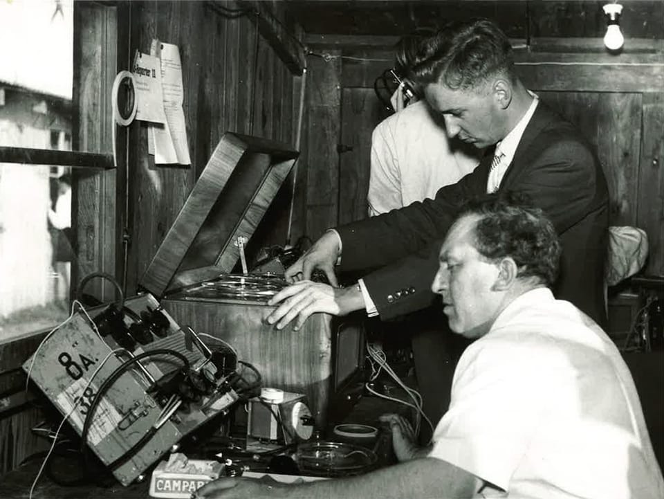Drei Techniker installieren Geräte für die Radioübertragung. 