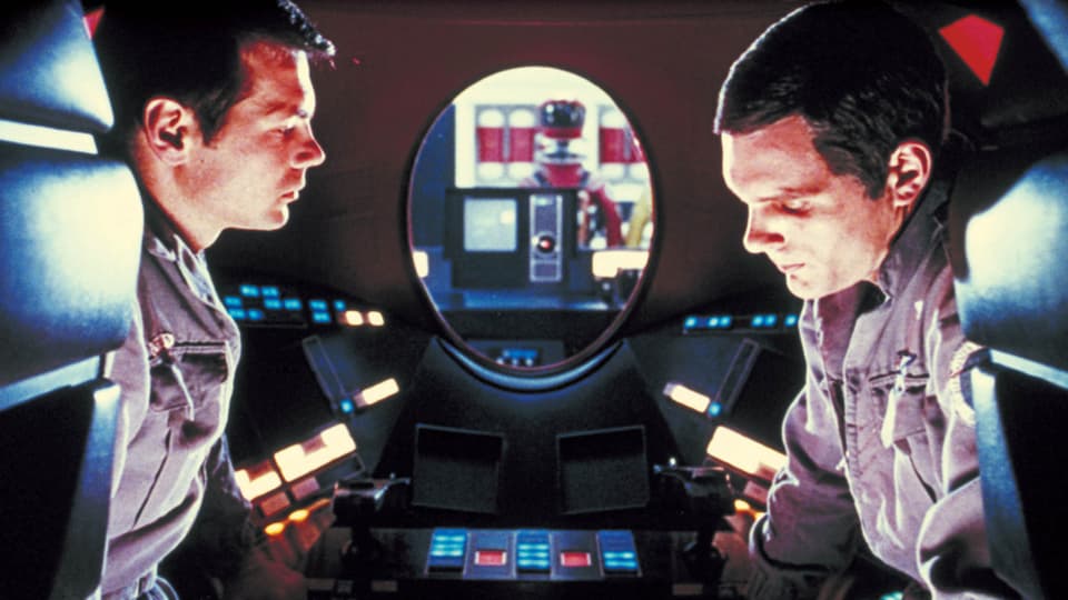 Zwei Männer im Cockpit eines Raumschiffs mit Computern