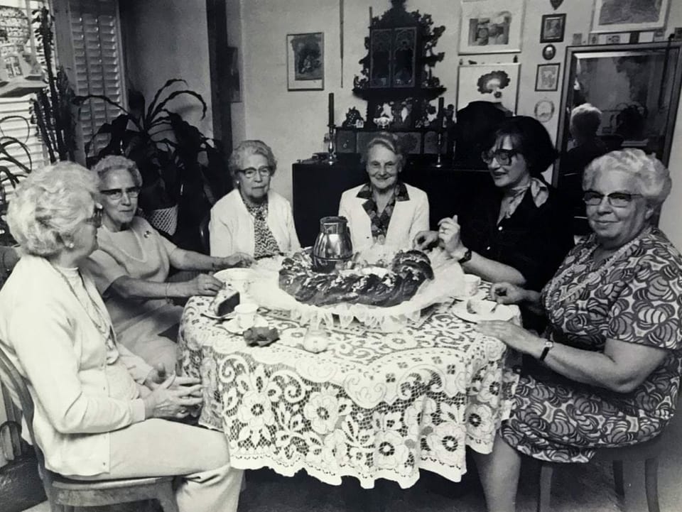 Sechs Frauen an einem runden Tisch.