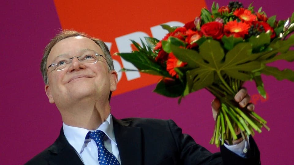 Weil hält einen Blumenstrauss in die Luft.