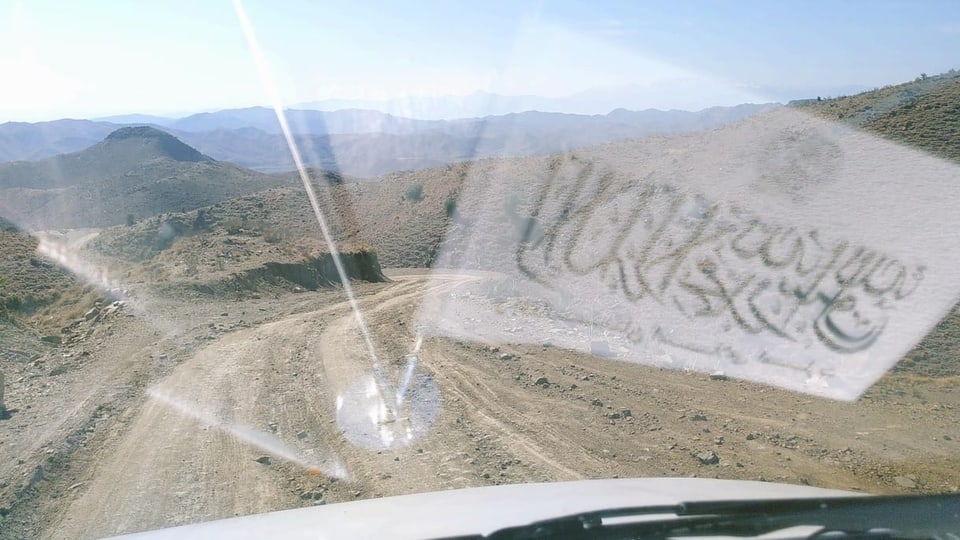 In der Windschutzscheibe eines Autos spiegelt sich die Flagge des Islamischen Emirates Afghanistans.