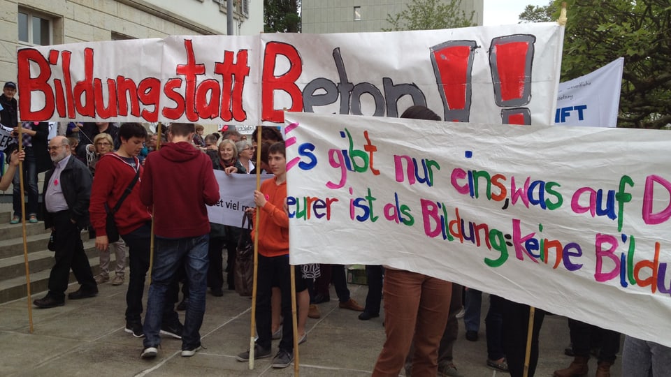 Menschen mit Plakaten, auf denen unter anderem steht: Bildung statt Beton