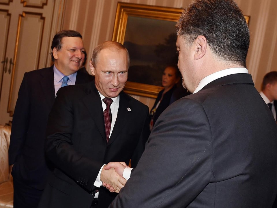 Putin schüttelt Poroschenko die Hand.