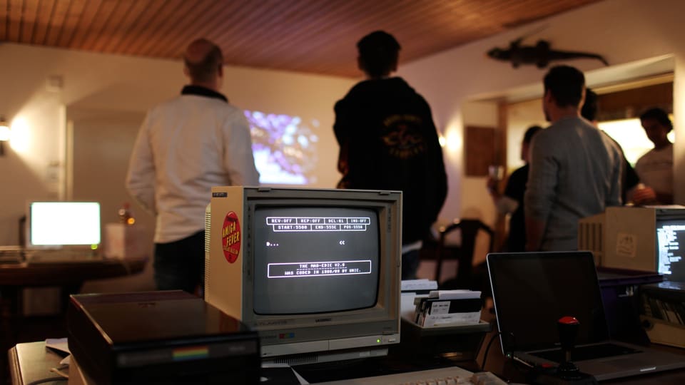 Commodore-64-Veteranen schauen sich in einem Kellerlokal «Demos» von früher an.