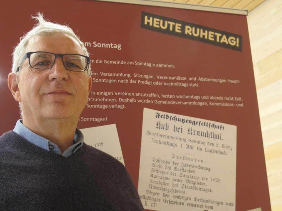 Ulrich Zwahlen vor der Wand mit den Anzeigen von Veranstaltungen, die am Sonntag stattfanden.