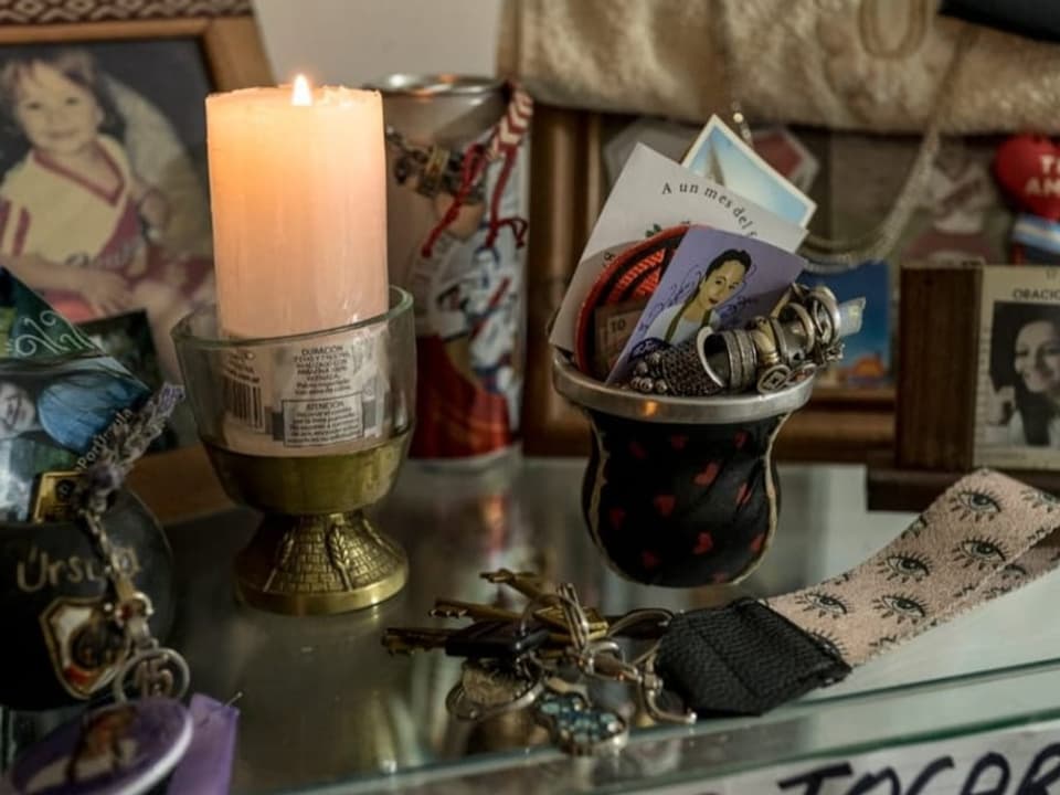 Altar mit Erinnerungsstücken und einer Kerze.