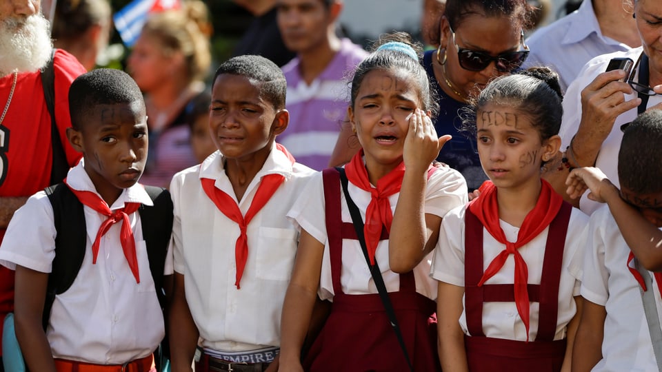 Kinder mit dem Namen Fidel Castros im Gesicht weinen