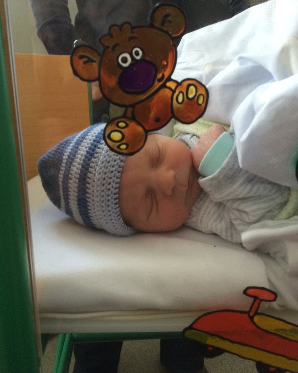 Ein Neugeborenes in seinem kleinen Spitalbett.