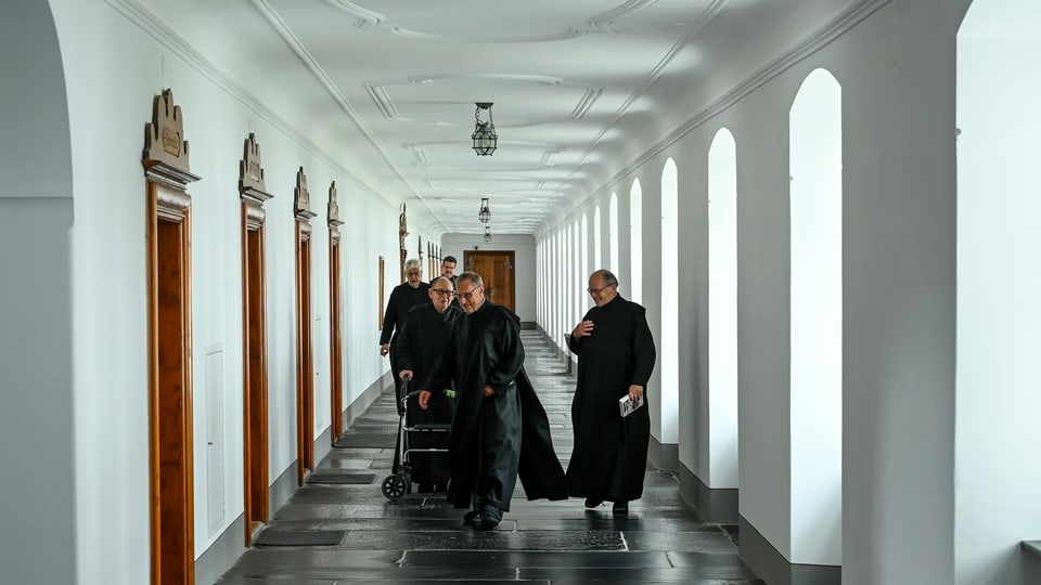 Mönche laufen in den Gängen des Klosters.