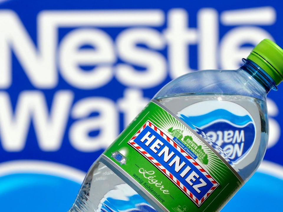 Henniez-Flasche vor dem Logo von Nestlé Waters
