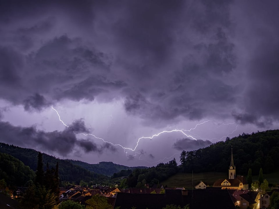 Blitz am Himmel über einem Dorf.