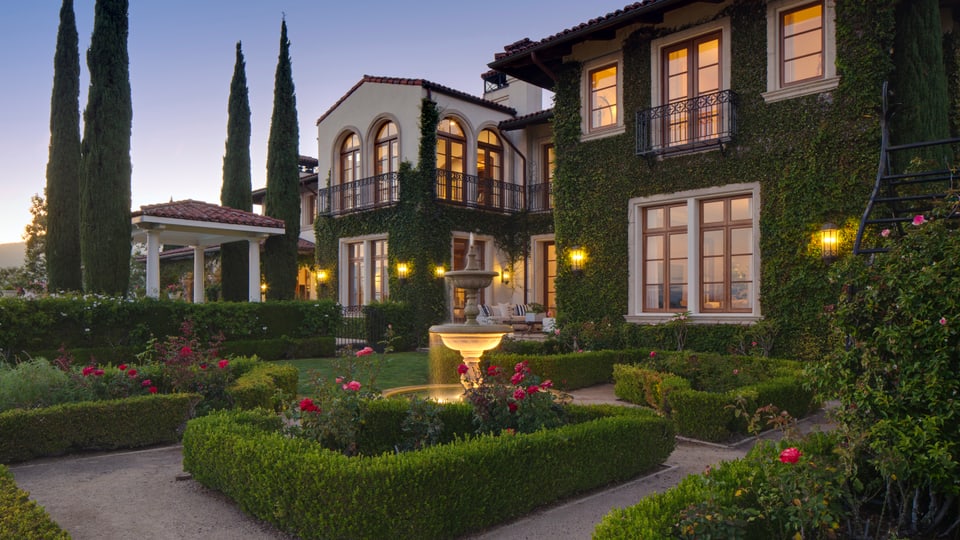 Ein Bild von Heidi Klums Villa mit Garten. Das ganze Anwesen ist mit Efeu bewachsen. 