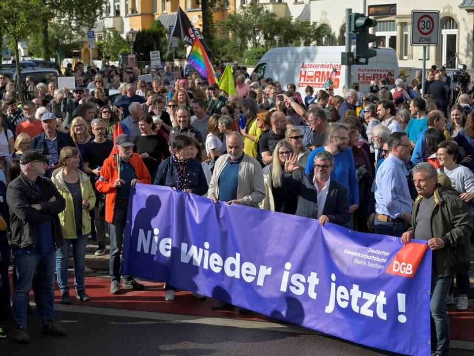 Menschenmenge bei einer Demonstration mit grossem Banner 'Nie wieder ist jetzt!'