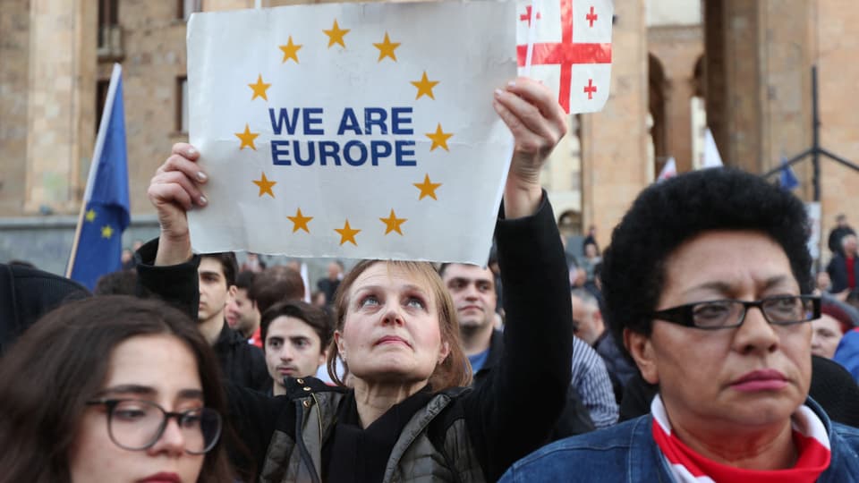 Menschen protestieren in Tiflis. Eine Frau hält ein Plakat mit «we are Europa» in die Höhe.