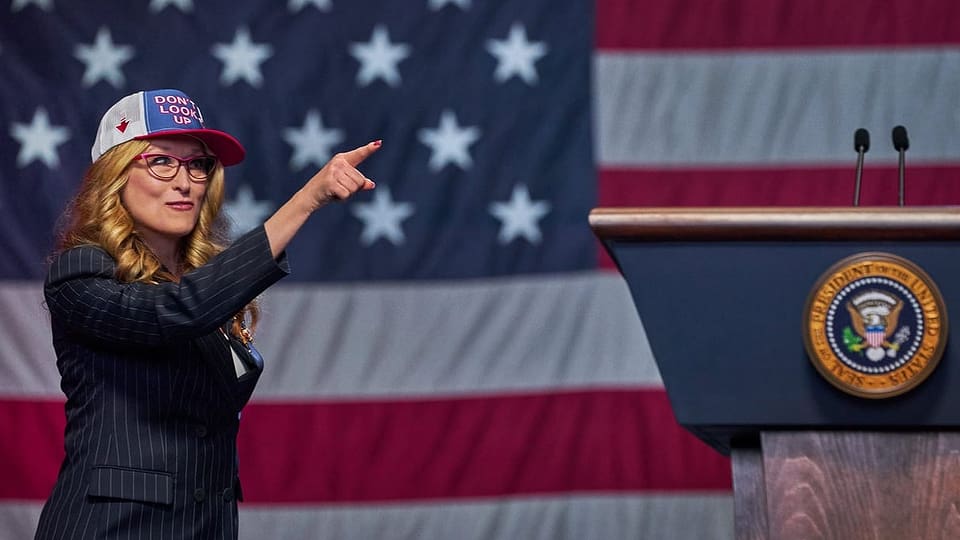eine Frau mit Kappe vor einer US-Flagge