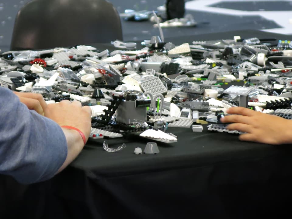 Erwachsene und Kinder-Hand in Lego-Teilen