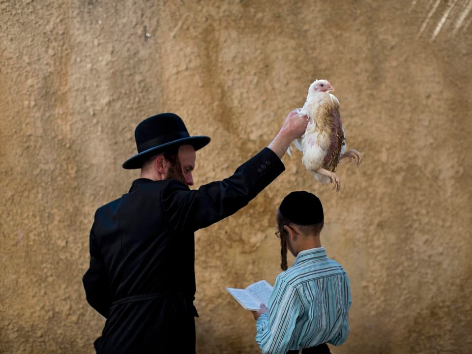 Ultraorthodoxer Jude schwenkt lebendes Huhn über Kopf eines Jungen
