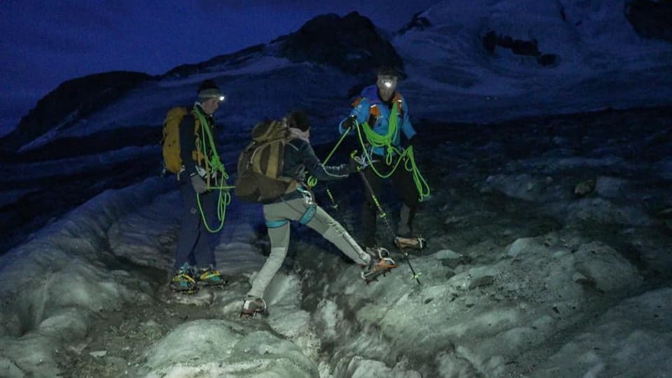 Drei Personen in der Dunkelheit auf dem Gletscher. Lalia Grillo überquert eine Gleschterspalte