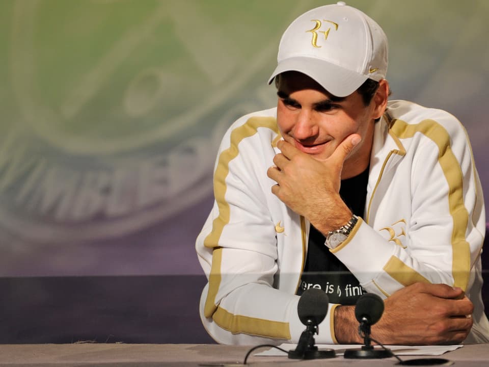Roger Federer lacht an der Pressekonferenz.