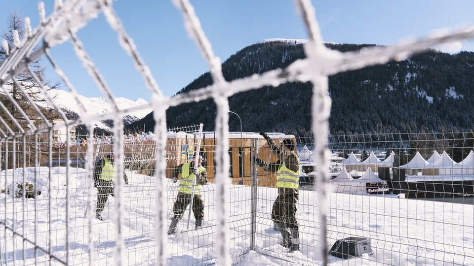 Drei Soldaten bauen einen Zaun für das WEF in Davos auf.