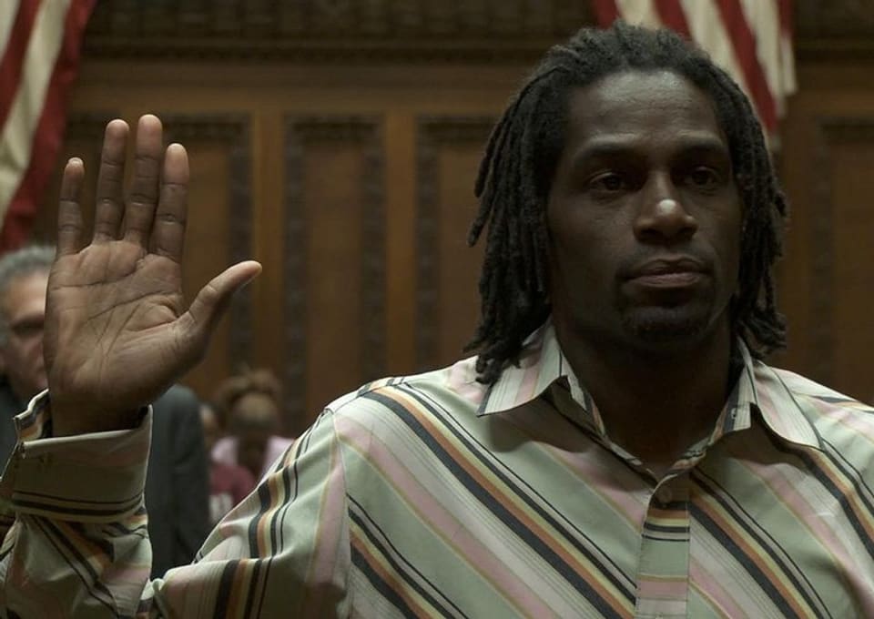Filmstill: Ein Schwarzer vor Gericht hebt die Hand zum Eid.