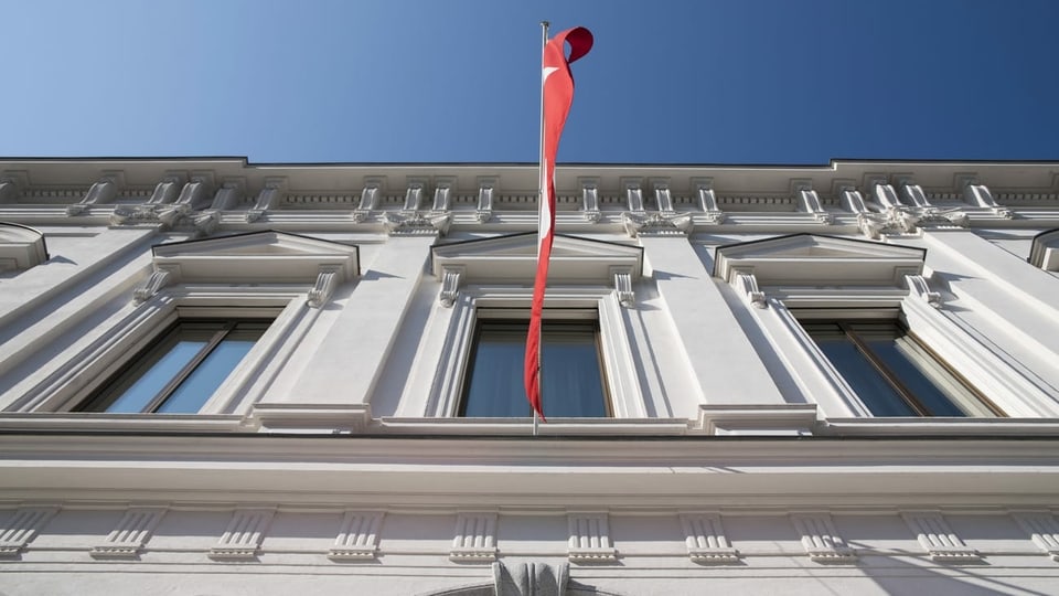 Gebäude des Bundesstrafgerichts fotografiert von unten, darauf auch eine Schweizerfahne, die über dem Eingang hängt.