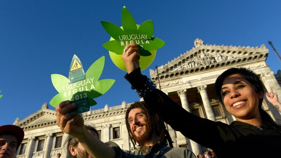  Aktivisten feiern die Annahme des Gesetzes vor dem Kongressgebäude in Uruguay. 