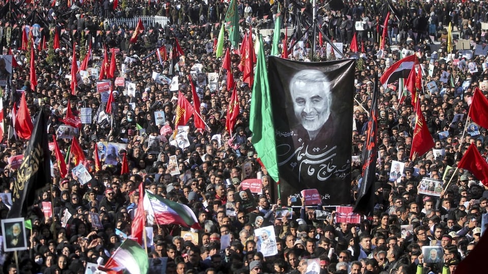 Menschenmenge mit Trasparent, auf dem Soleimani abgebildet ist.