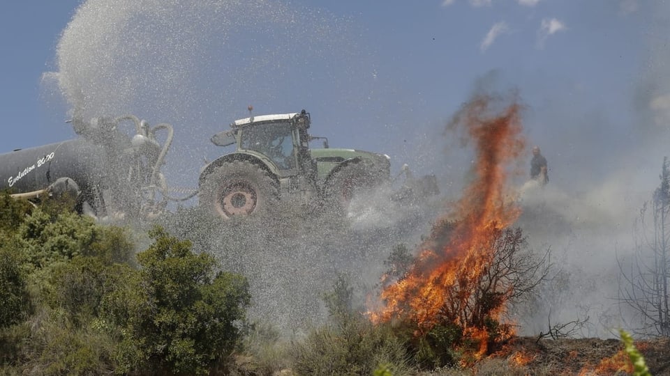 Aus einem Traktor, der ein brennendes Feld in Spanien passiert, 