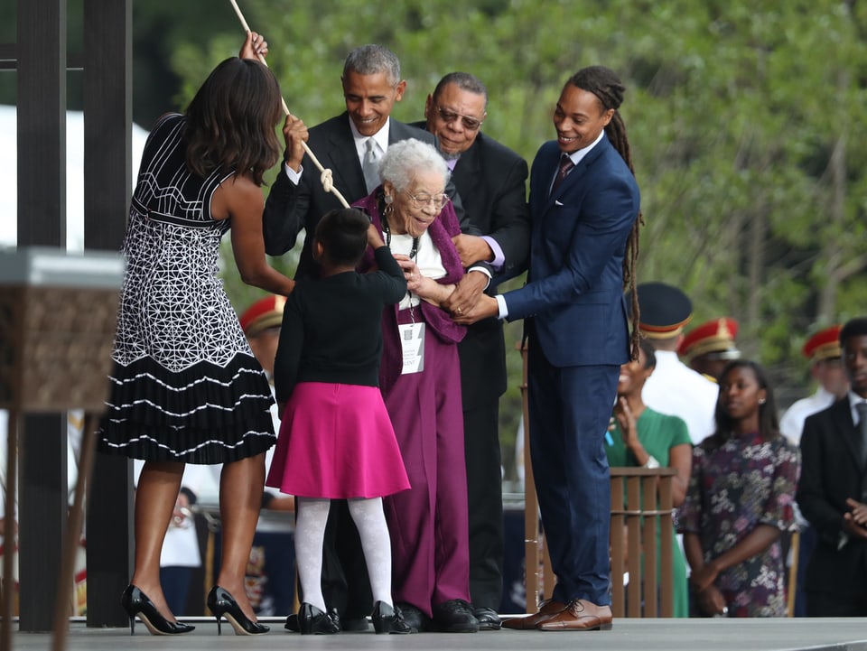 Ruth Bonner zieht an einer Schnur, daneben Barack Obama und weitere Menschen