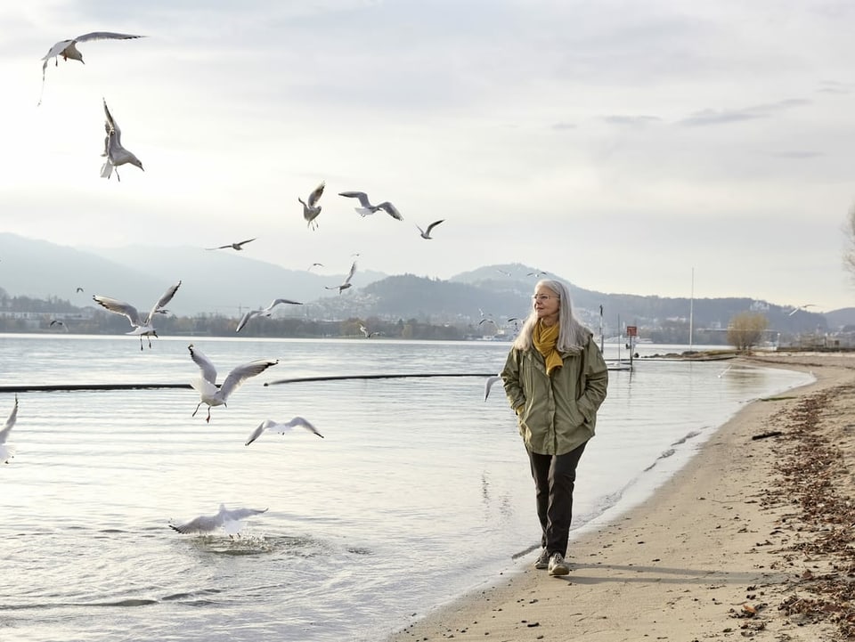 Frau spaziert am Ufer