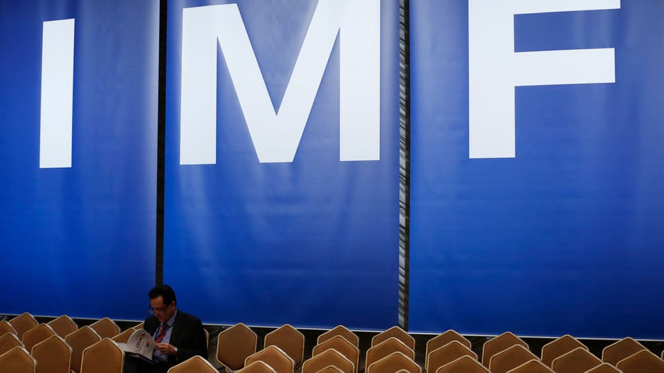 Eine Wand mit den Buchstaben IMF für International Monetary Fund bei einer Konferenz.
