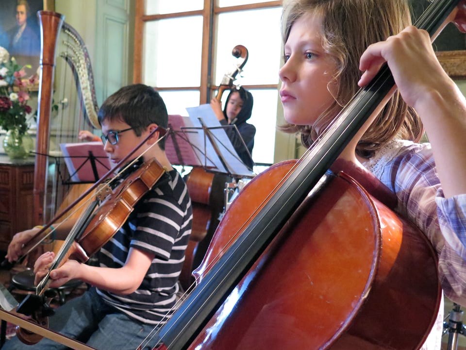 Ein Kind spielt Cello, ein anderes Bratsche.