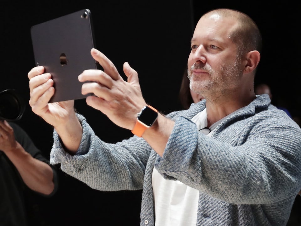 Jony Ive hält sich ein iPad vors Gesicht.