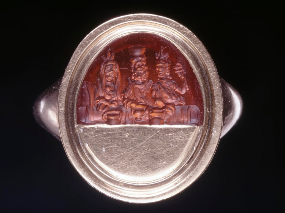 braun-metallener Ring, im braunen sind zwei Figuren eingraviert