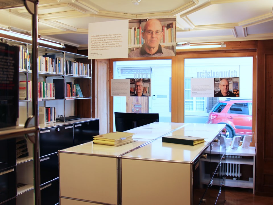 Tisch an Fenster - links ein Büchergestell.