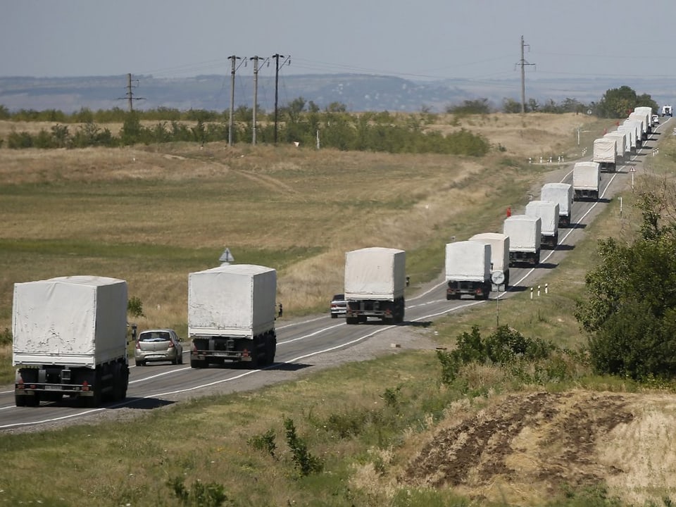 Ein Konvoi aus weissen Lastwagen im russisch-ukrainischen Grenzgebiet.